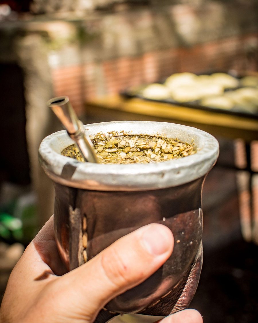 Mate con bombilla sostenido en la mano